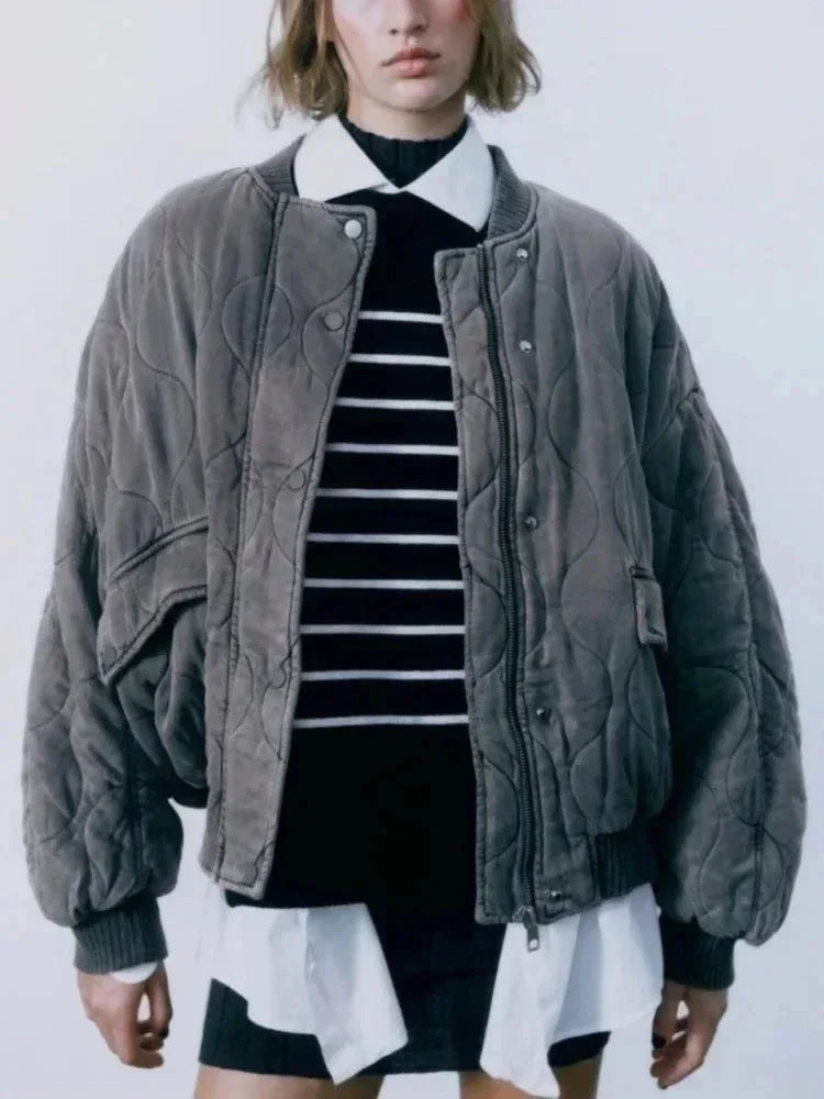 Women's quilted bomber jacket in navy, featuring snap closures and ribbed cuffs for a comfortable fit in cool weather.