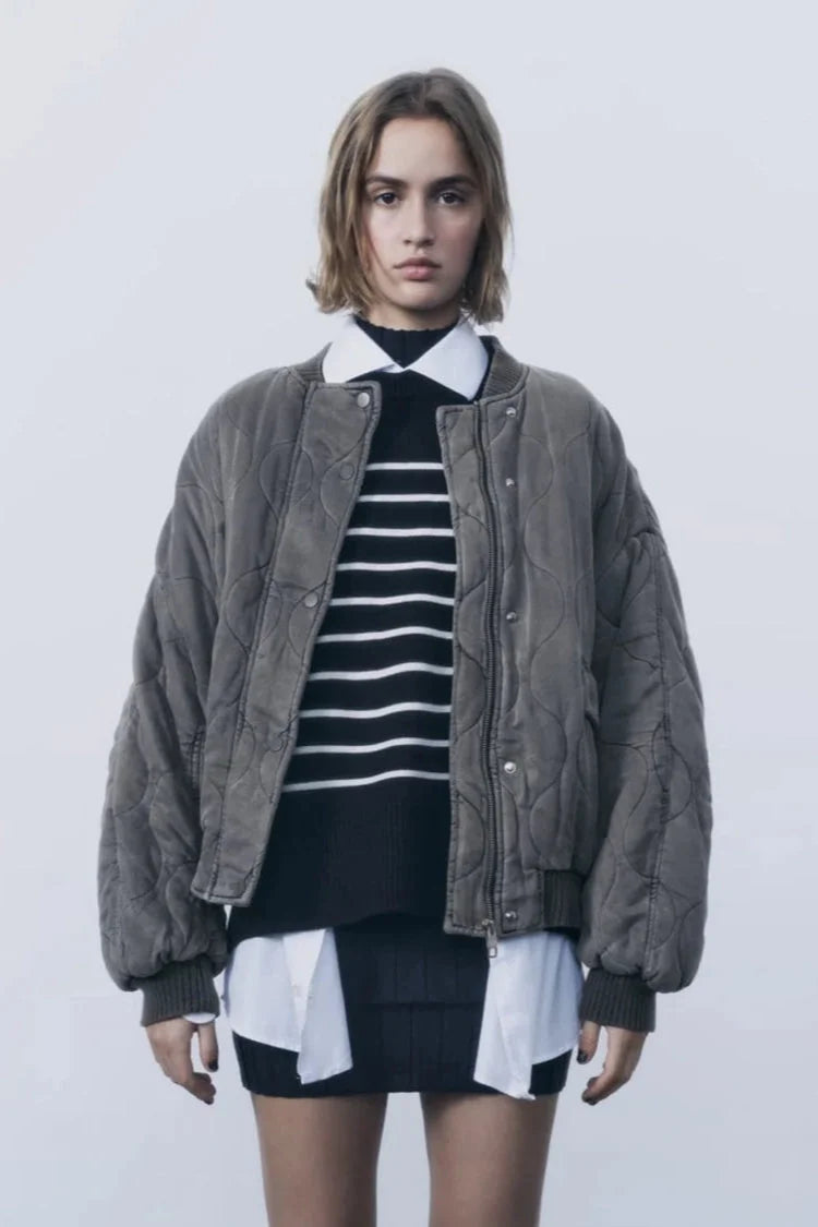 Women's quilted bomber jacket with snap closures, featuring a warm fabric, ribbed cuffs, and a stylish, streamlined…