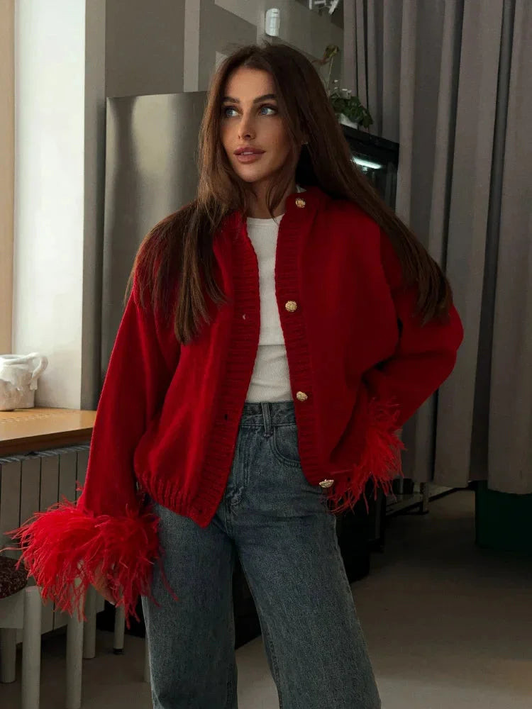 Women's red cardigan featuring feather sleeves and a button front, made from soft knit fabric for warmth and style.