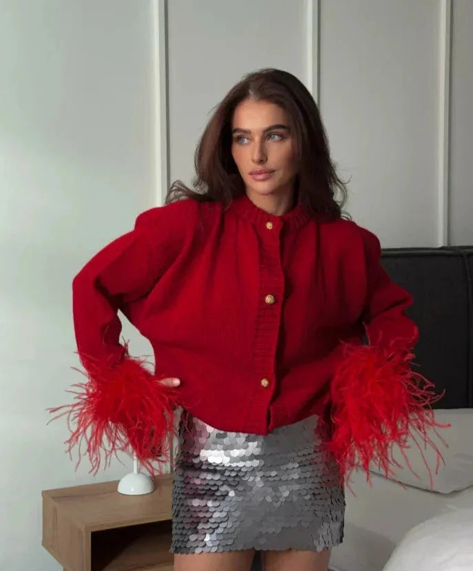 Women's red cardigan featuring feather sleeves, a button front, and soft knit fabric for warmth and style.
