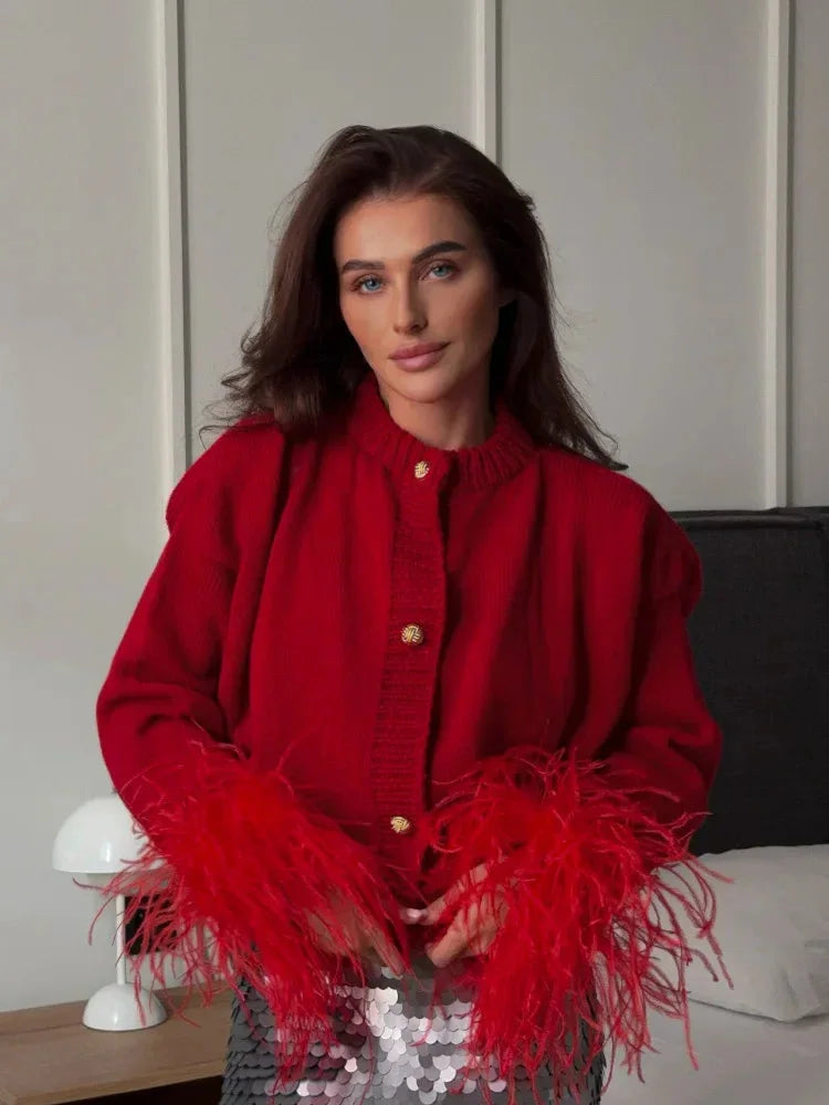 Women's red cardigan featuring feather sleeves and button front, crafted from soft fabric for comfort and style.