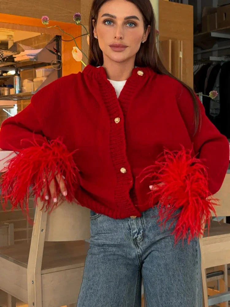 Women's red cardigan with soft fabric, feather sleeves, and button front for a stylish, cozy look. Perfect for layering.