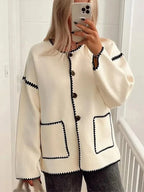 Women's relaxed fit cardigan in soft knit with contrast stitching, featuring an open front and side pockets for added…