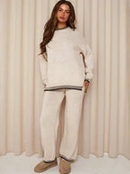 Cozy women's relaxed fit sweater and pants set made from soft cotton blend, featuring a minimalist design and comfortable…