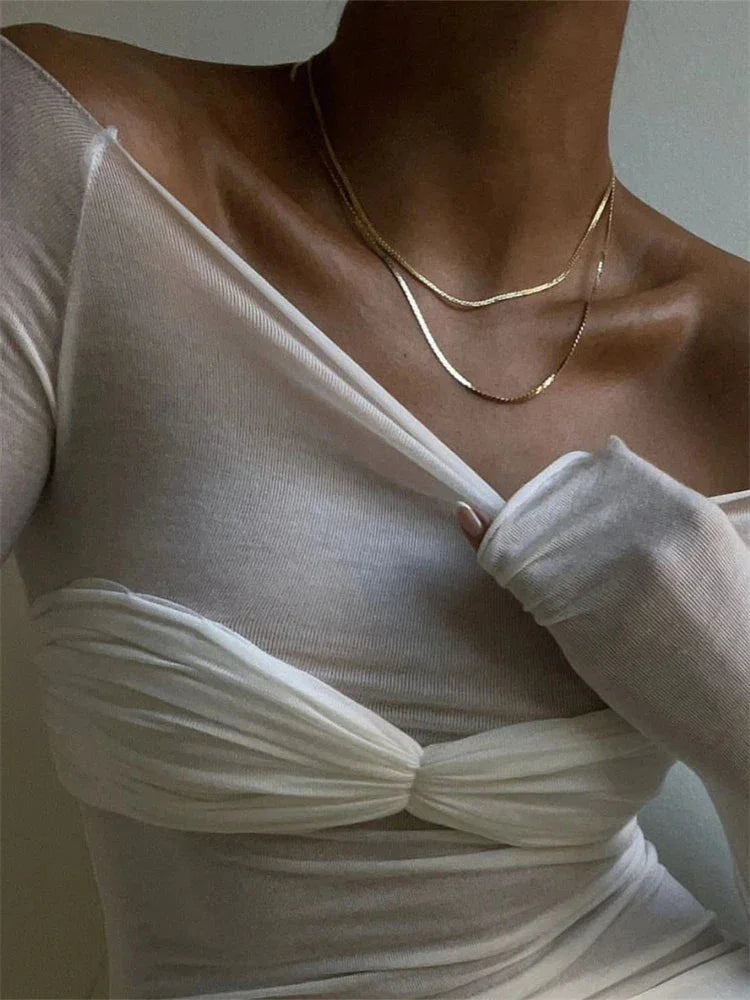 Women's sheer off-shoulder ruched top made from lightweight fabric, featuring a fitted silhouette and elegant neckline.
