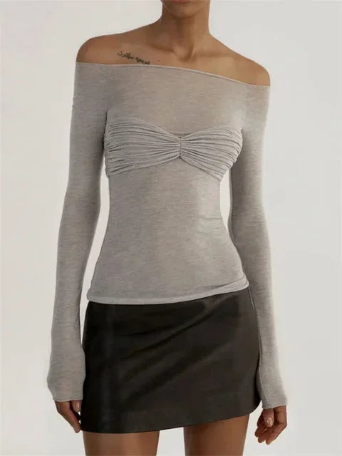 Women's sheer off-shoulder ruched top in lightweight fabric, featuring ruffled edges and a fitted silhouette for a…