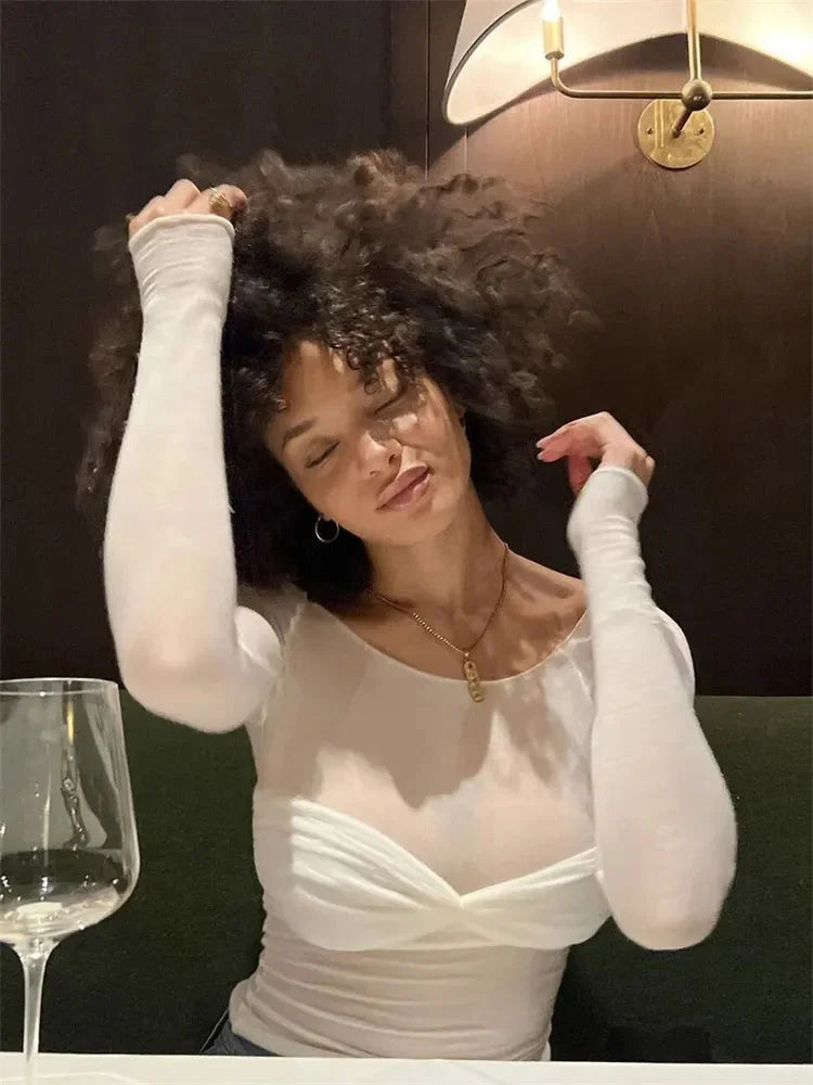 Women's sheer off-shoulder ruched top in lightweight fabric, featuring ruffled edges and a fitted silhouette for a stylish…