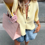 Women's short sleeve button-up cardigan in soft cotton, featuring a classic design with ribbed edges and a relaxed fit.