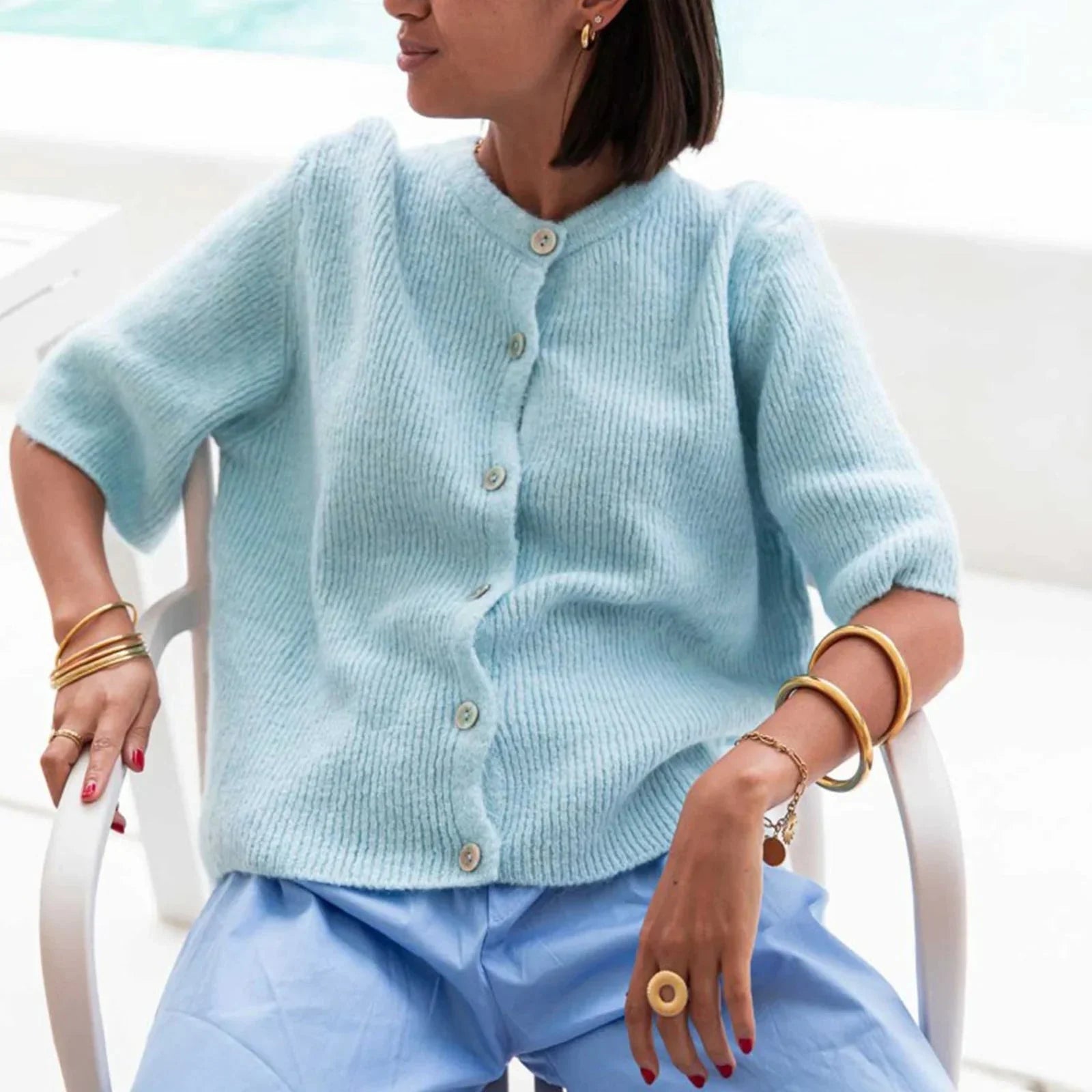Women's short sleeve button-up cardigan made from soft cotton blend with a relaxed fit and classic button-down design.