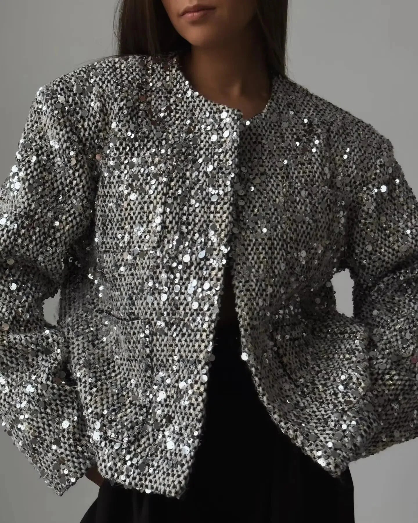 Women's silver sequin open front jacket featuring a shimmering sequin exterior and a relaxed fit for easy layering.