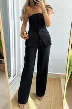 Women's strapless asymmetric pantsuit in soft fabric, featuring stylish buttons and practical pockets for added convenience.