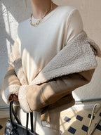 Women's suede jacket featuring faux shearling lining and zip closure, ideal for layering in cool weather.