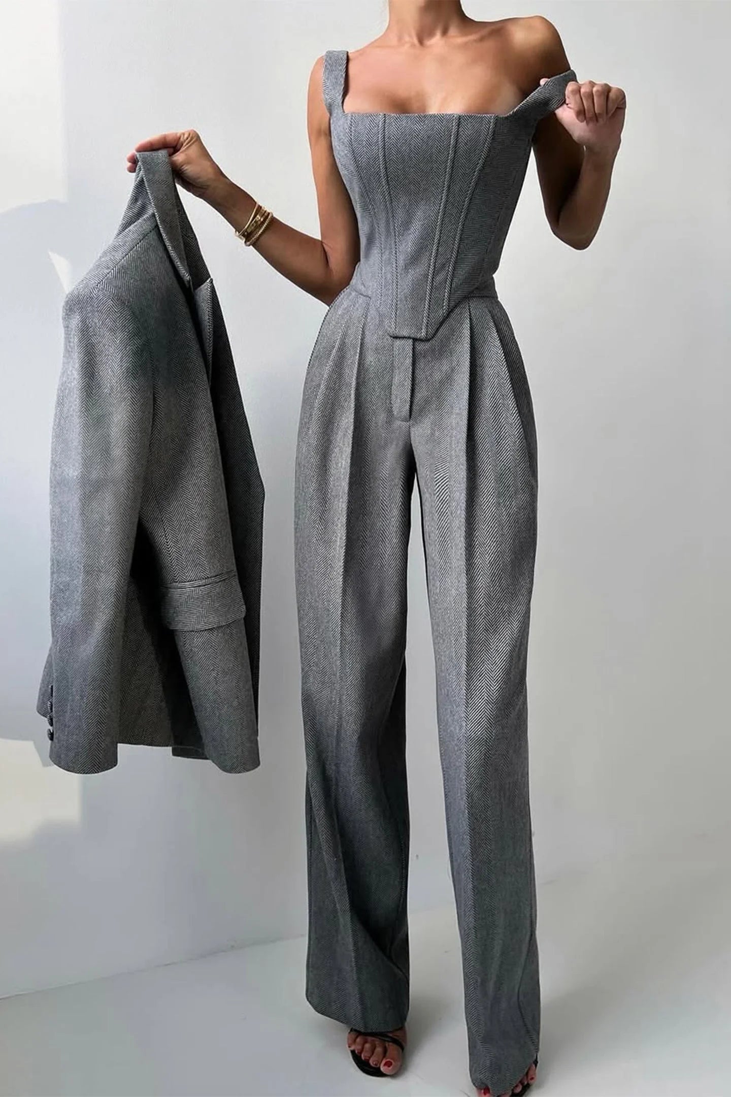 Women's three-piece fitted top and trousers set in soft fabric, featuring structured design and tailored fit for a polished…