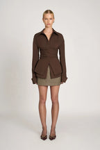 Women's tailored wrap blouse with long sleeves, featuring a soft fabric and adjustable waist tie for a flattering fit.