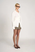 Women's tailored wrap blouse with long sleeves in soft cotton blend, featuring a fitted silhouette and stylish wrap design.