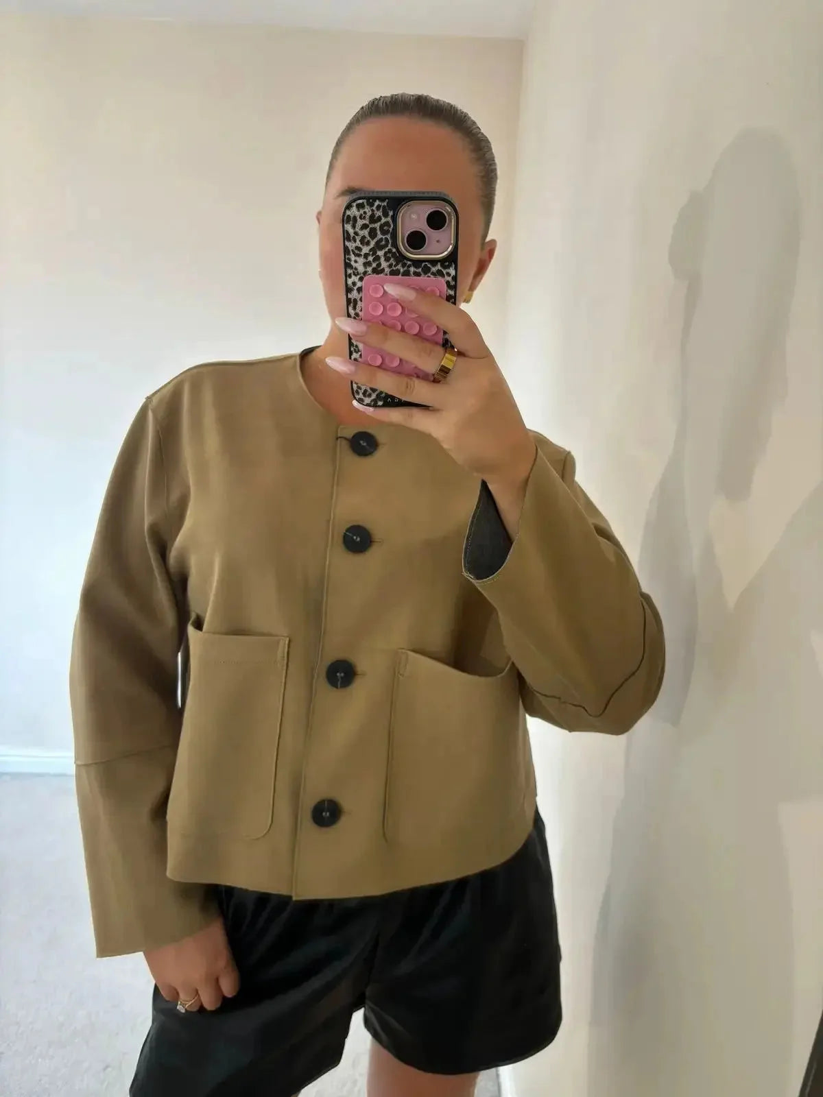 Women's tan suede jacket with long sleeves and button-up front, featuring a classic design and soft texture.