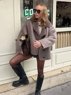 Women's taupe coat features a buttoned front, shawl collar, and soft fabric for warmth during colder seasons.
