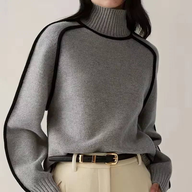 Women's turtleneck knit sweater featuring contrast trim, made from soft fabric for warmth and comfort in colder weather.