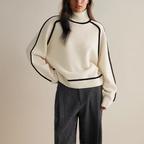 Women's turtleneck knit sweater featuring contrast trim, made from soft cotton blend for cozy wear during colder seasons.