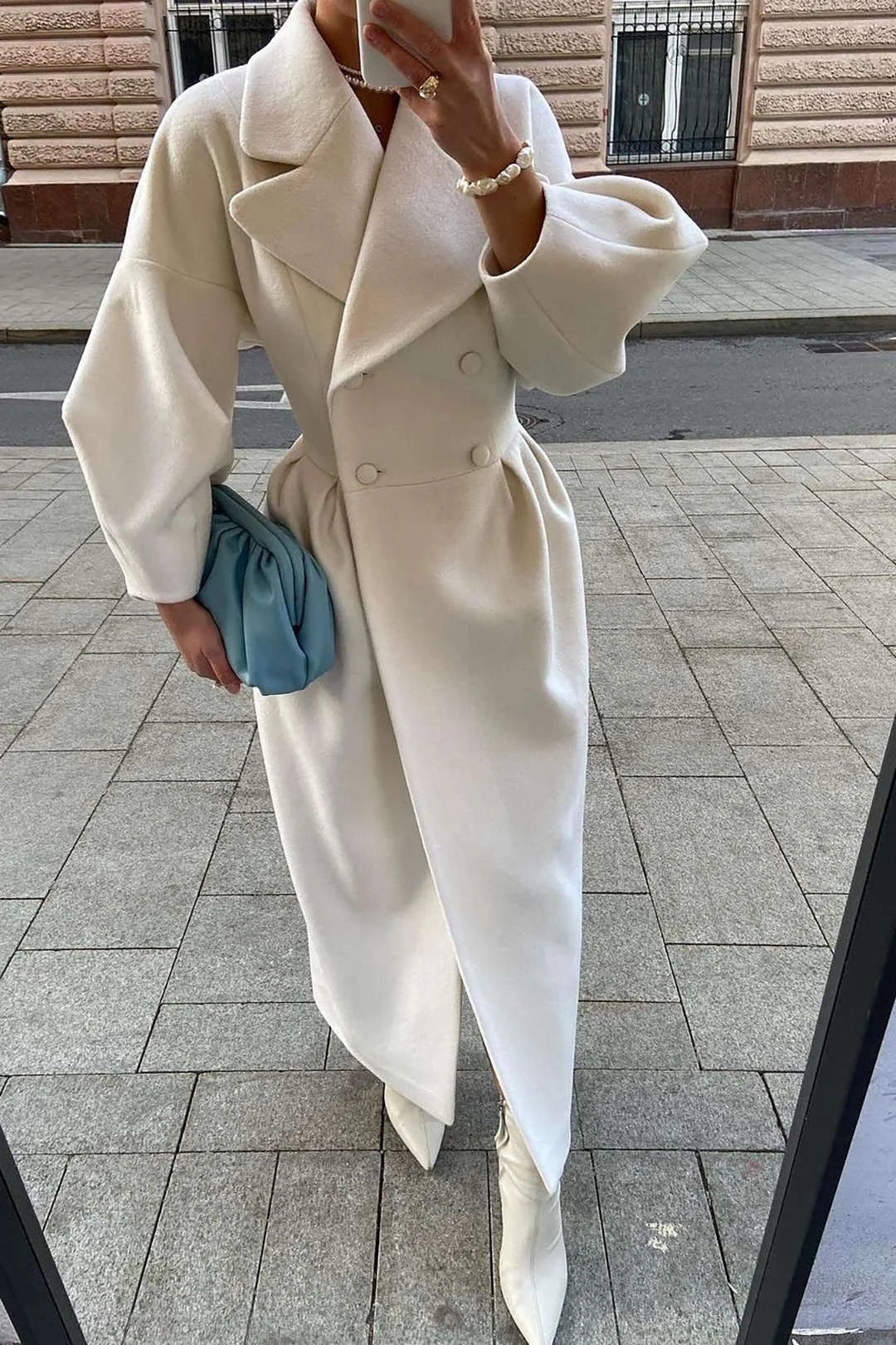 Women's white belted long coat featuring a wide collar, crafted from soft fabric for warmth and style.