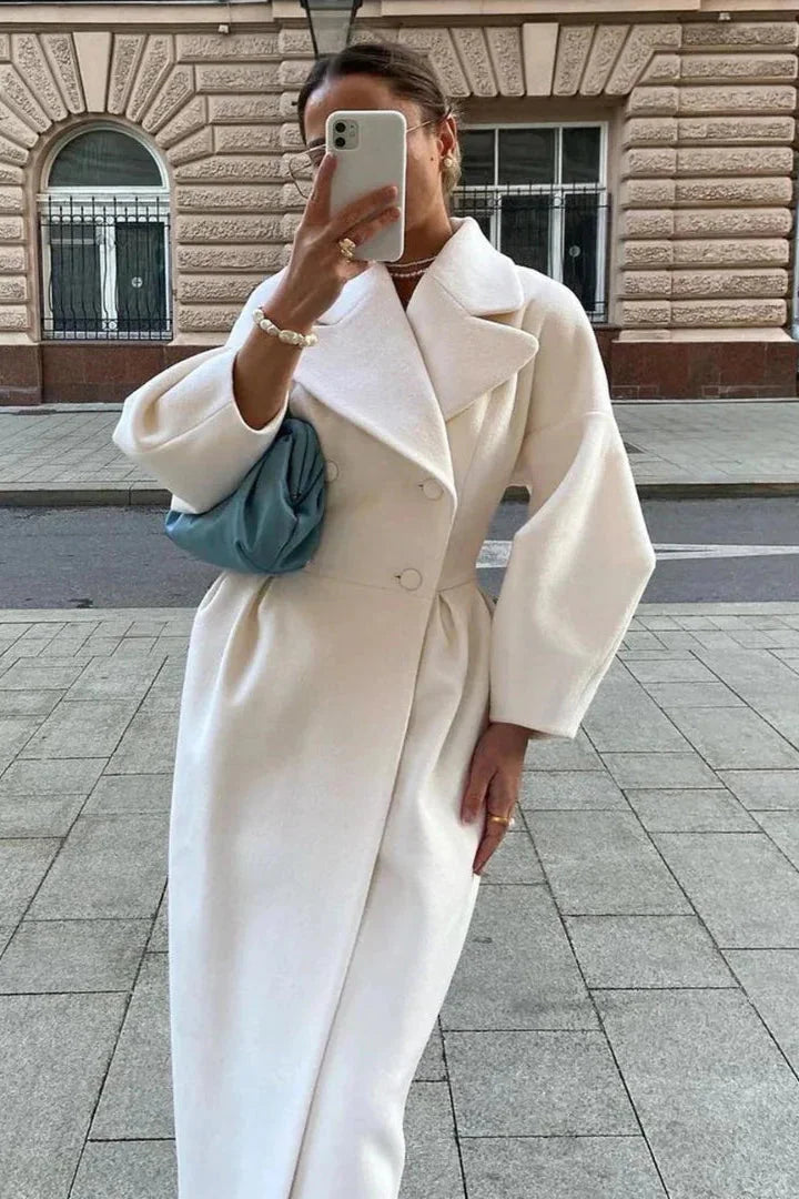 Women's white belted long coat featuring a wide collar, made from a soft fabric with a tailored fit for a sleek silhouette.