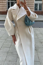 Women's white long coat with a belt and wide collar, made from soft fabric, perfect for stylish layering in cool weather.