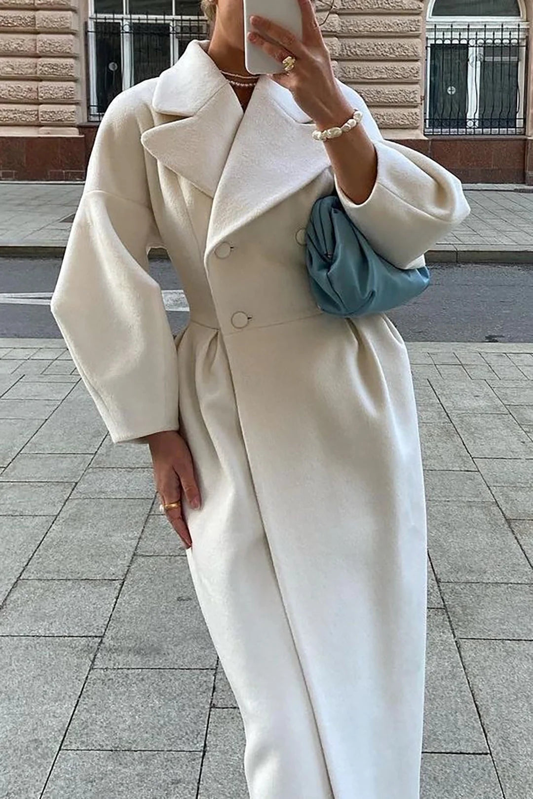 Women's white long coat with a belt and wide collar, made from soft fabric, perfect for stylish layering in cool weather.