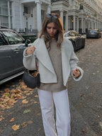 Women's white short coat with oversized sleeves, made from lightweight fabric, featuring a tailored fit and minimalistic…